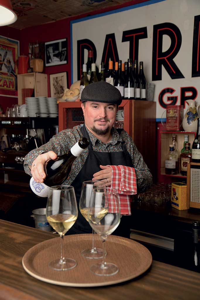Mathieu dodard, propriétaire du Restaurant Le Millésime à Bourg-en-Bressse dans l'Ain, avec une bouteille de Vin du Bugey AOC