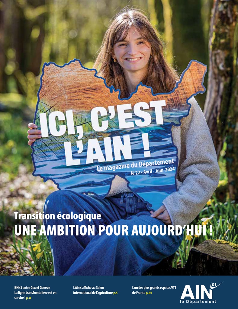 Couverture du magazine Ici c'est l'Ain : une jeune femme aindinoise souriante assise dans la forêt