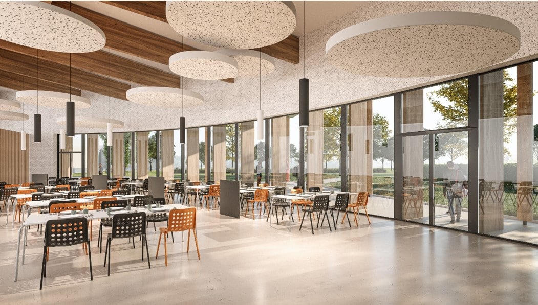 Salle lumineuse avec de grandes verrières, des tables et des chaises