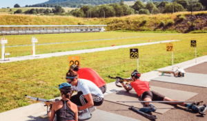 2 sportifs allongés avec des fusils de compétition sur le Stade de biathlon aux Plans d'Hotonnes labellisé « Sport Adapté » Département de l'Ain