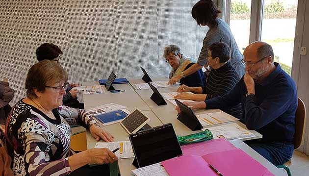 Activités et animation séniors : Atelier numérique un groupe de séniors assis autour d'une table avec chacun une tablette dans le cadre d'un atelier sur le numérique